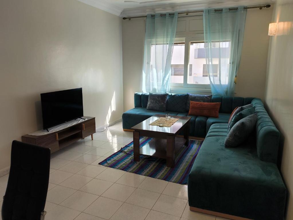 a living room with a green couch and a table at Chez Atlas in Kenitra