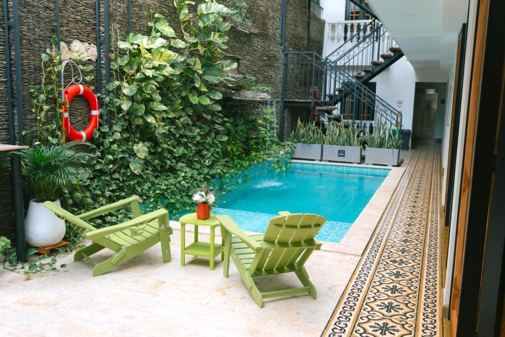 a swimming pool with two chairs and a table at La Brisa Loca Prime in Santa Marta