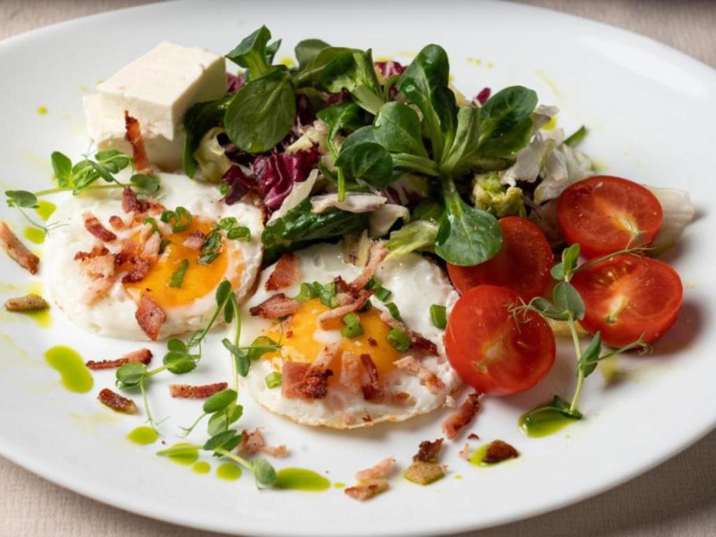 a plate of food with eggs and vegetables on a table at Barrique 24-4 - Breakfast delivered & Minibar - Free Parking -Officially classified guesthouse in Braşov