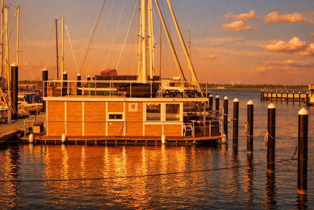 a small boat is docked at a dock at ÖKO Budget Hausboot Retreat Mondschein in Stralsund