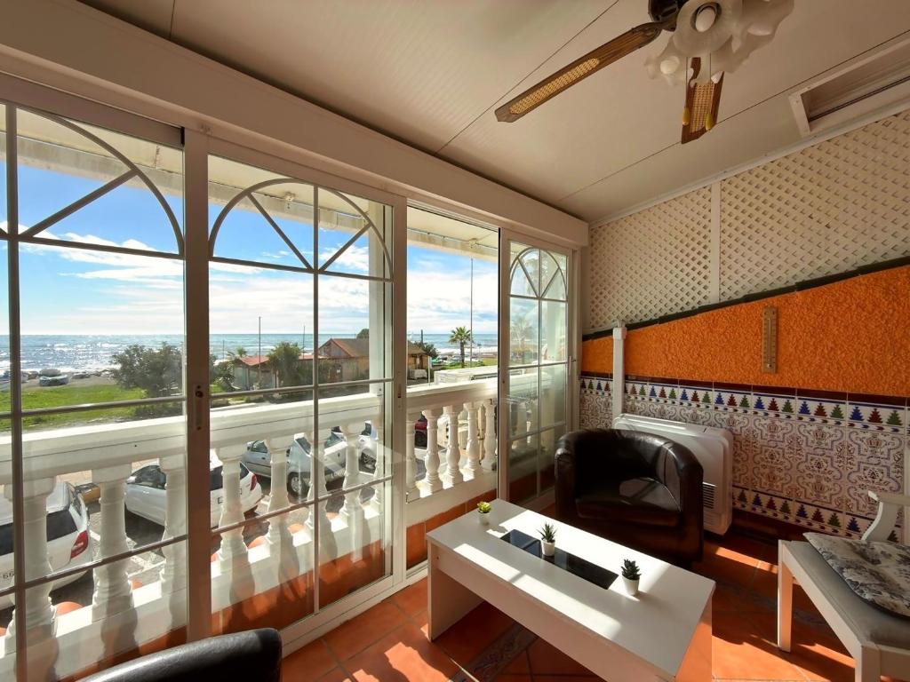 a living room with a large room with windows at Beach House Victoria - Beachside - Playa Rincón in Rincón de la Victoria