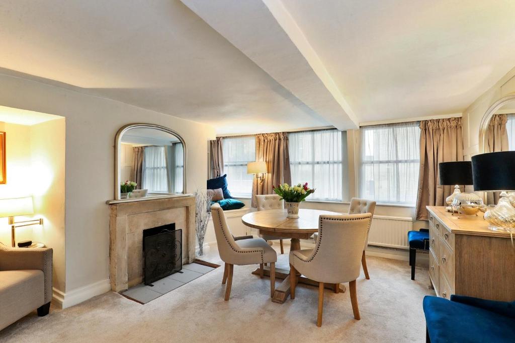 a living room with a table and a fireplace at Finest Retreats - Aarons in Painswick