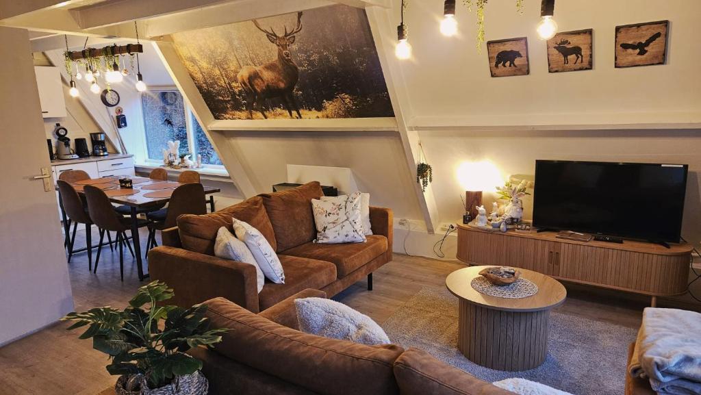 a living room with a couch and a television at de bosdriehoek II in Durbuy