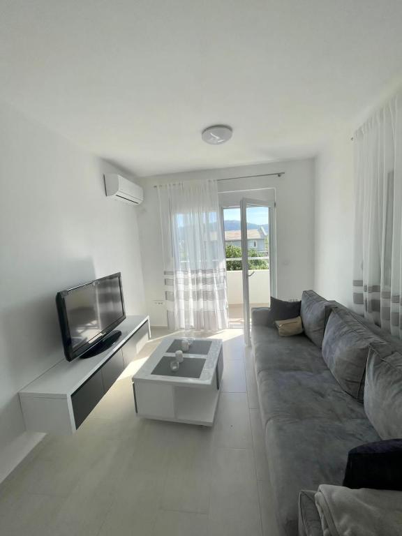 a living room with a couch and a tv at Sun Stay in Bar