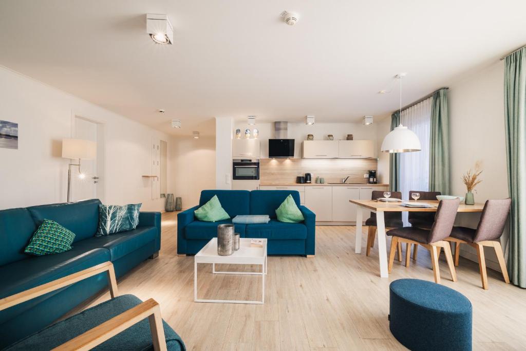 a living room with a blue couch and a table at Am Park 15 in Prerow