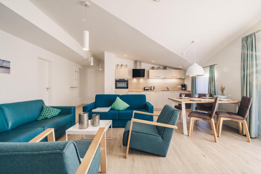a living room with blue couches and a table at Am Park 25 in Prerow