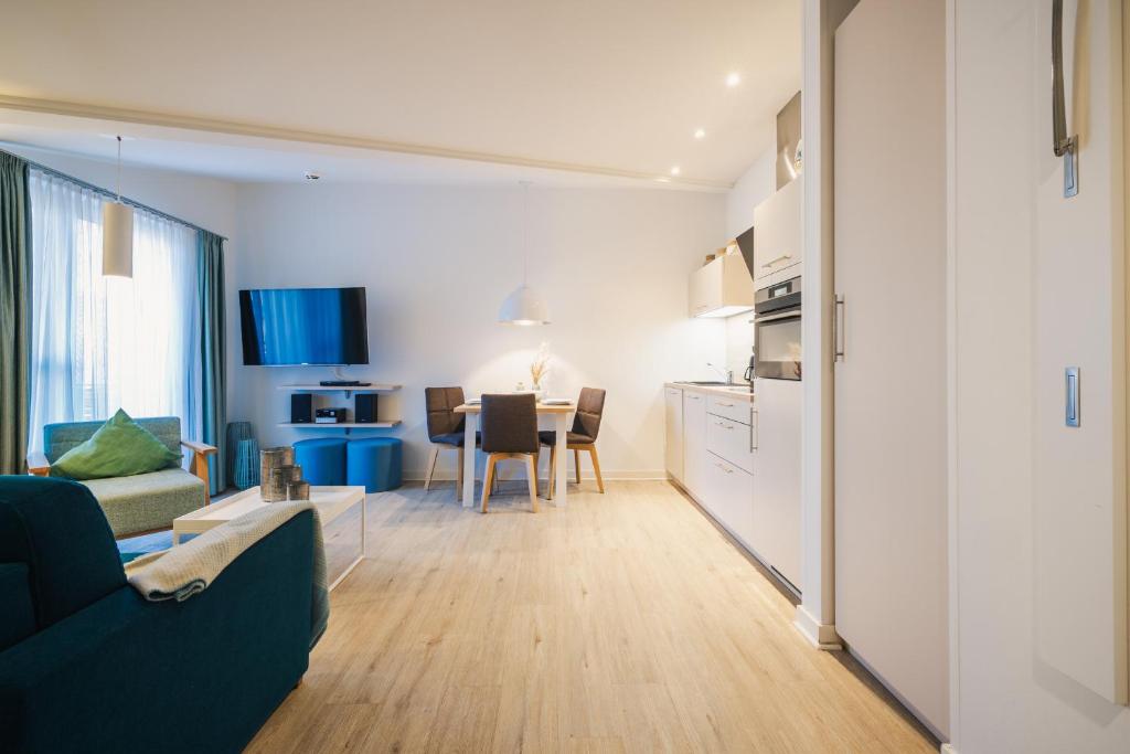 a kitchen and living room with a couch and a table at Am Park 24 in Prerow
