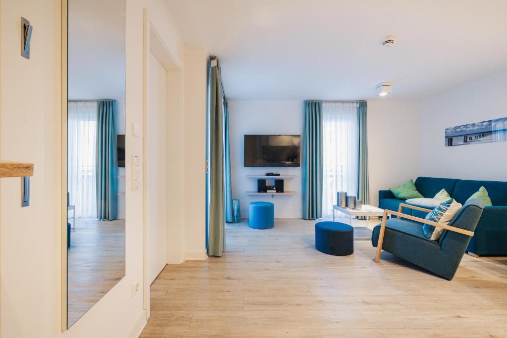 a living room with a blue couch and a table at Am Park 13 in Prerow
