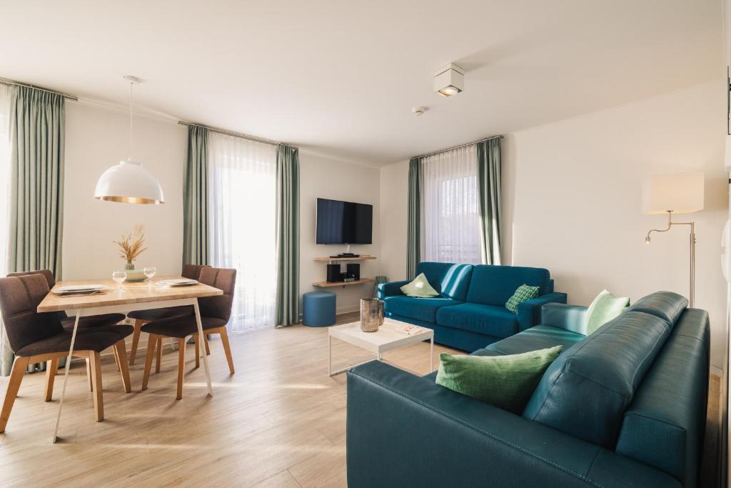 a living room with a blue couch and a table at Am Park 16 in Prerow