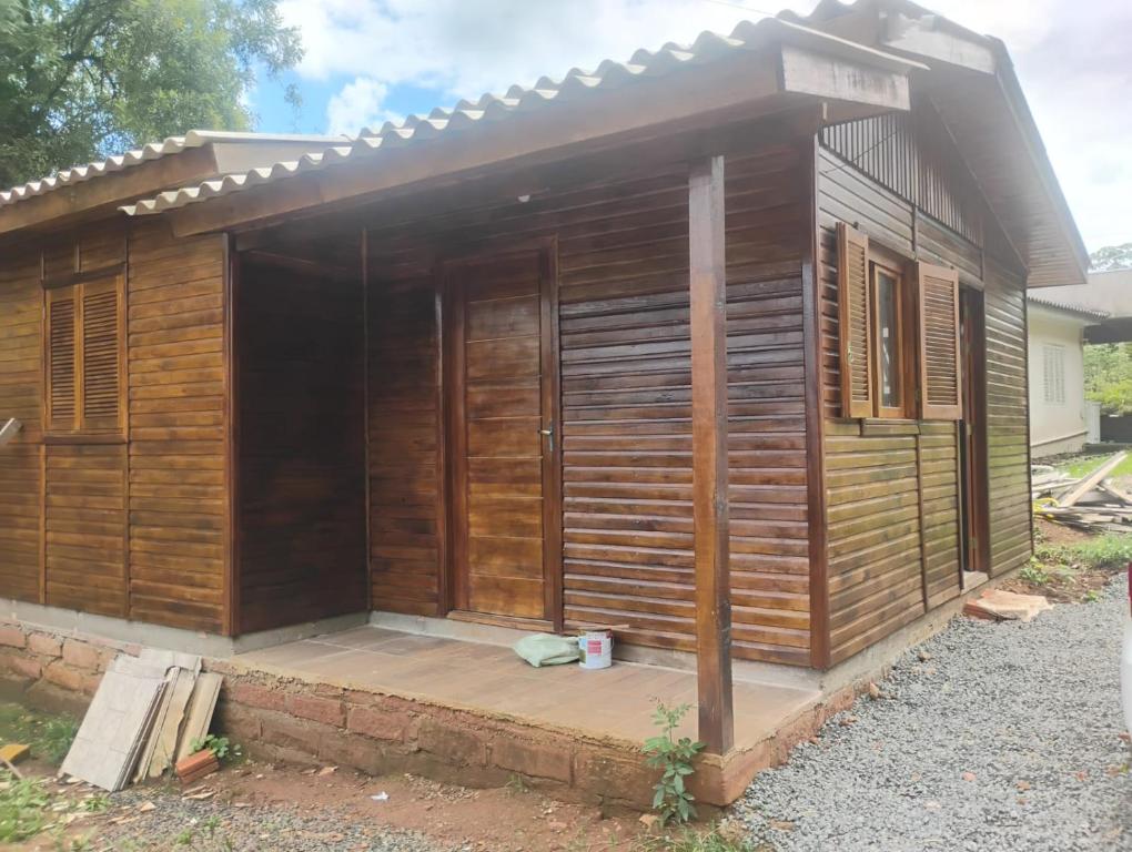 a small wooden building with a porch at Casa de Temporada BR 470 in Cafundó