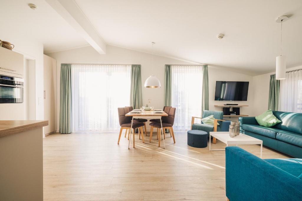a living room with a blue couch and a table at Am Park 26 in Prerow