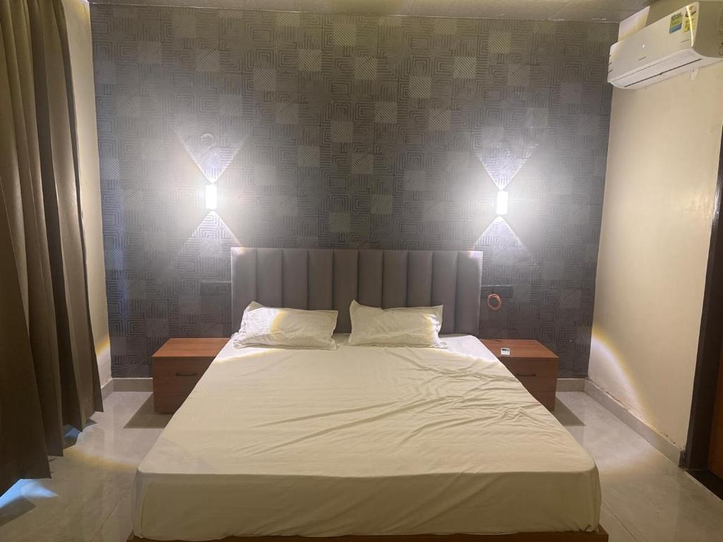 a bedroom with a bed with lights on the wall at Hotel nine hearts in Pānīpat