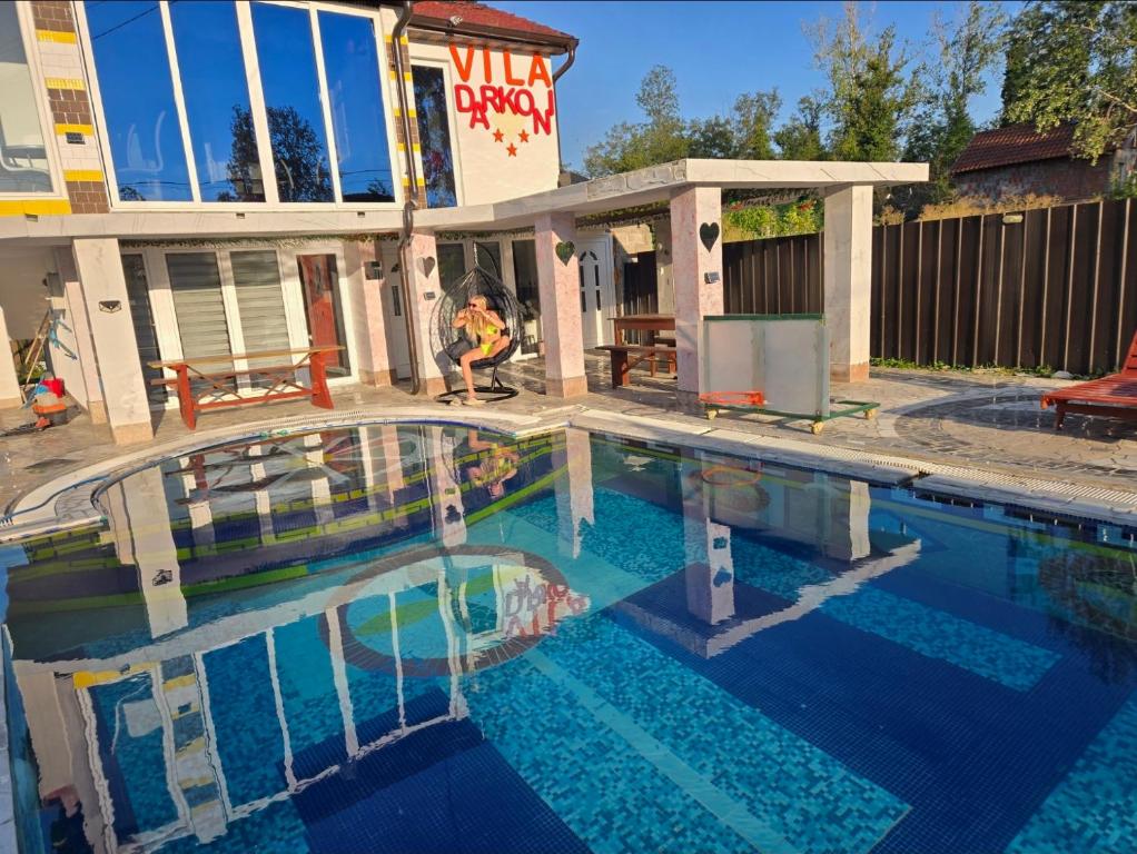 a person is standing next to a swimming pool at vila darkoni in Bijeljina