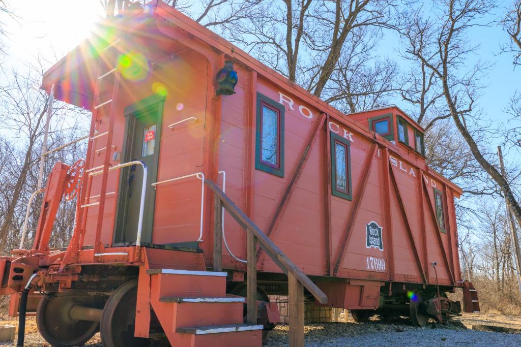 a red train car sitting on the tracks at The Train Station in Salina