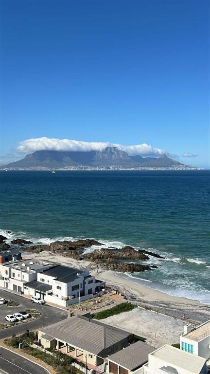 a view of the ocean and a beach with mountains at Blouberg Heights in Cape Town