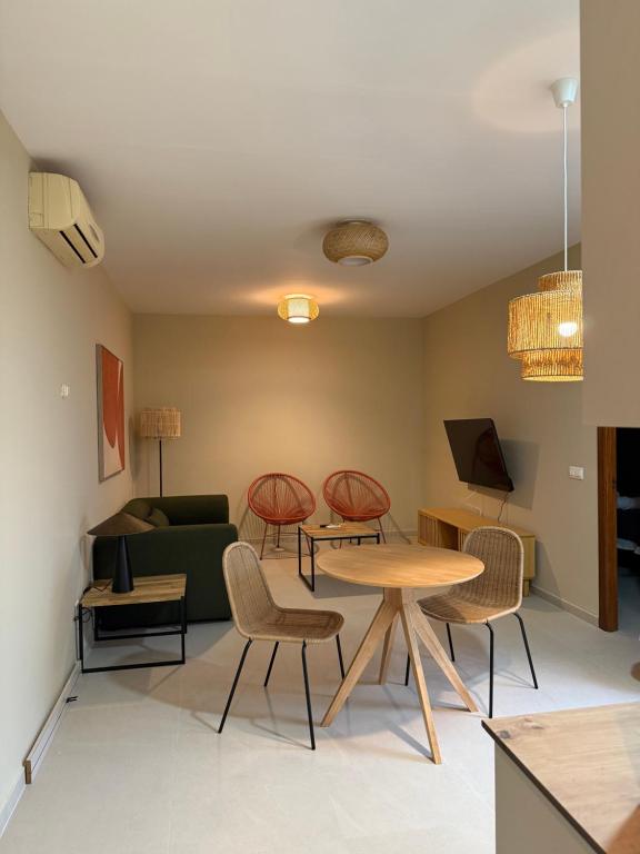 a living room with a table and chairs and a couch at Apartamentos Turísticos La Terraza* in Las Cabezas de San Juan