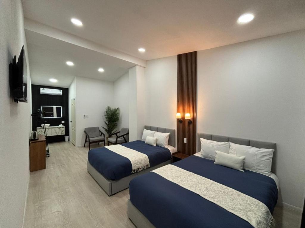 a hotel room with two beds and a television at Borunda Suites in General Trías