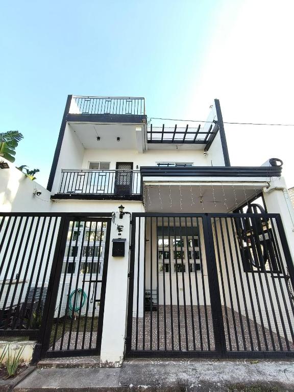 a white house with a black gate at Casipe Transient House in Tanay