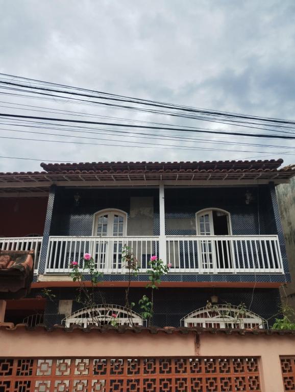 a house with a balcony with flowers on it at Casa Espaçosa para 10 Pessoas com Área de Churrasco e Garagem in Rio das Ostras