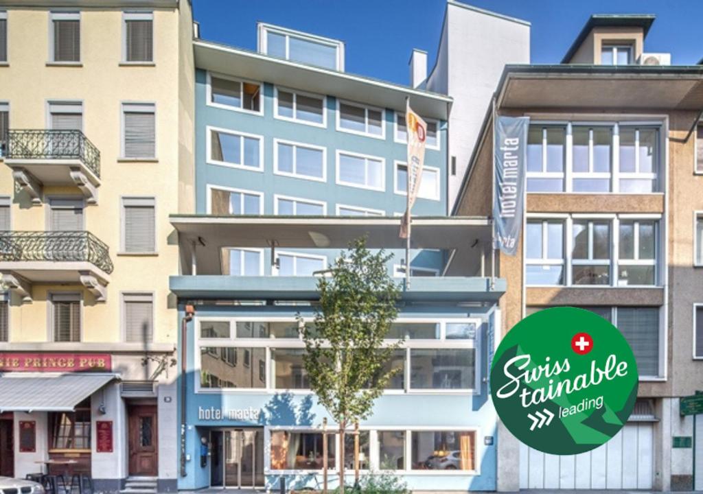 ein Gebäude mit einem Schild davor in der Unterkunft Hotel Marta - 1950's architecture in Zurich's vibrant old town, near main station in Zürich