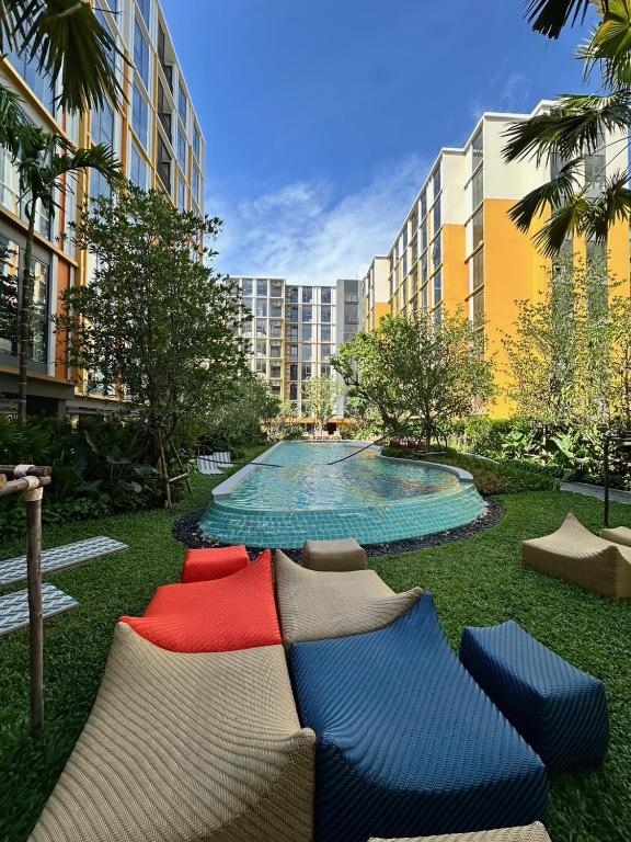 a group of pillows sitting on the grass near a pool at Rest&Rise Phuket in Ban Rangeng