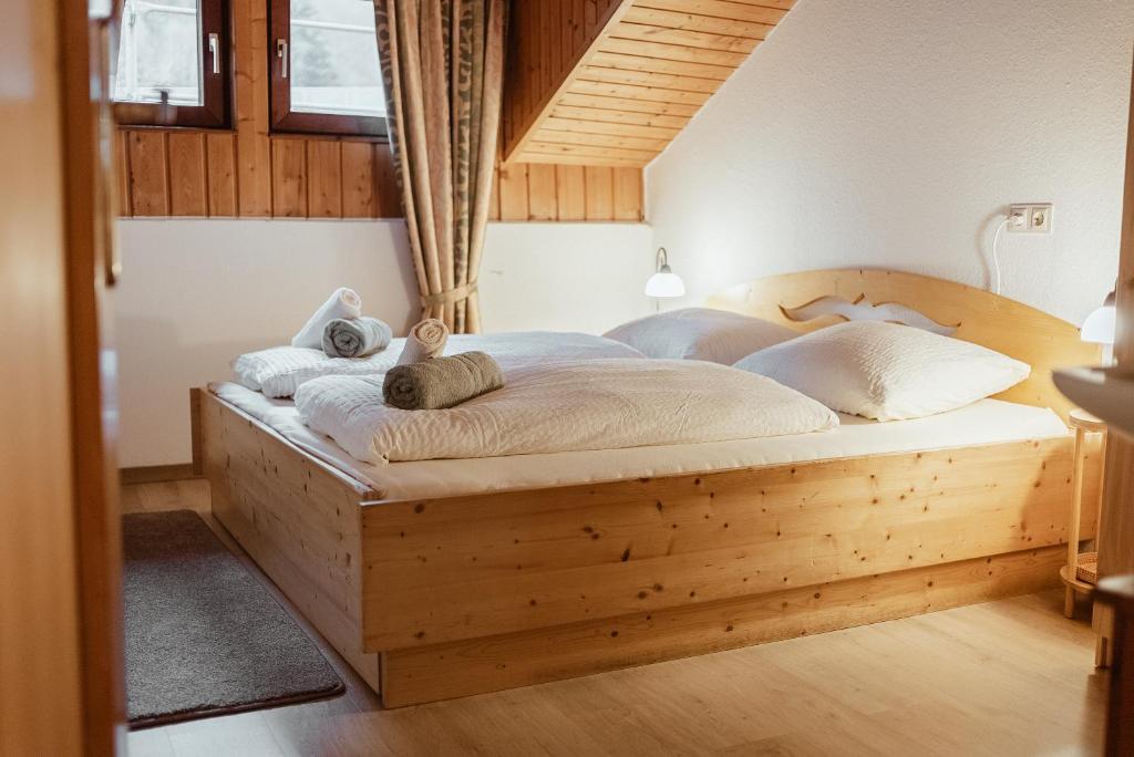 a bedroom with a wooden bed with towels on it at Haus Erlenau in Dalaas