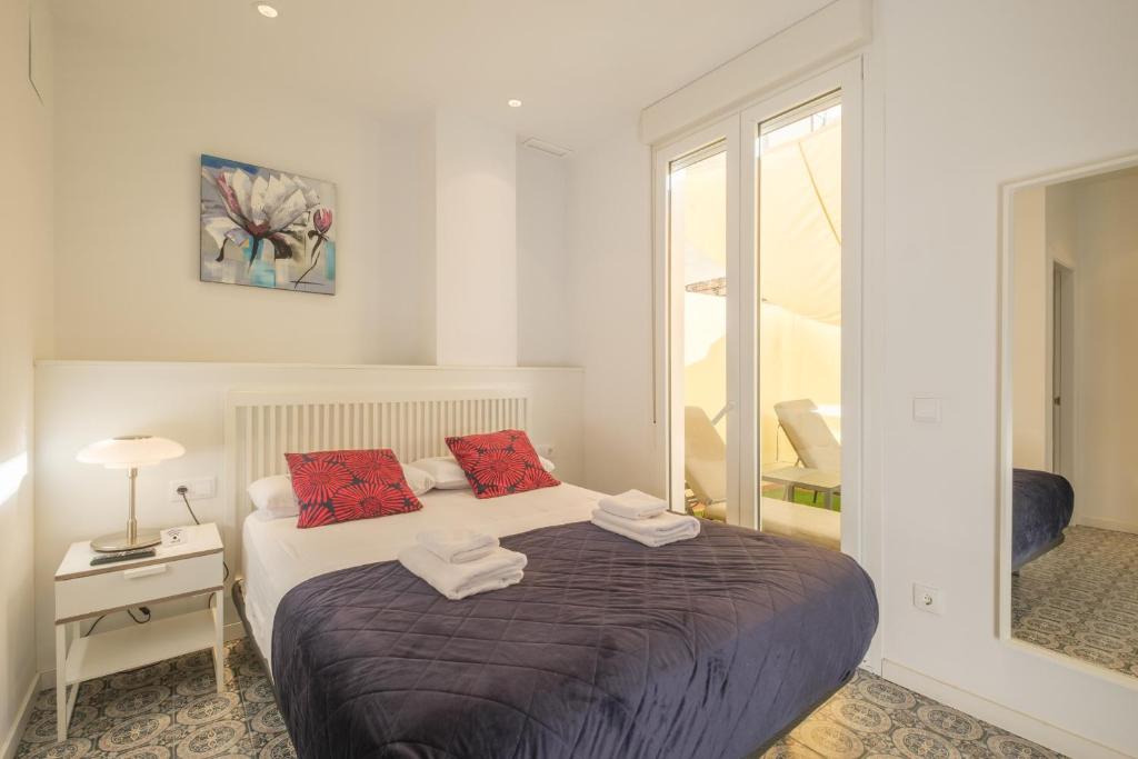 a bedroom with a bed with red pillows on it at Gorgeous Apt with a Large Private Terrace in Valencia