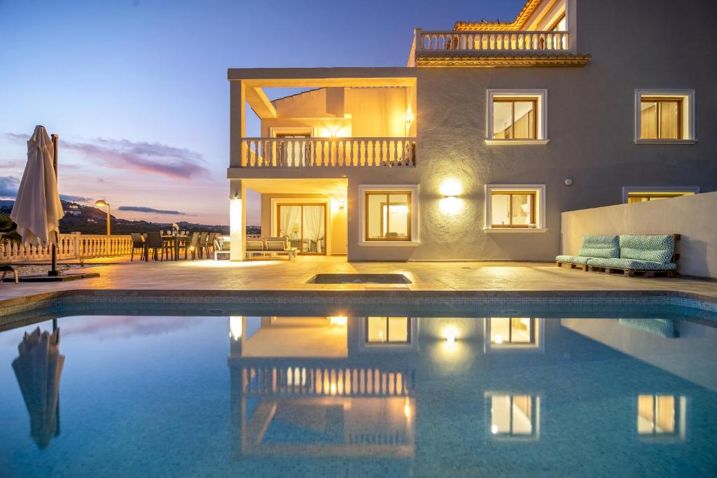 a villa with a swimming pool in front of a house at Villas Guzman - Grandiosa in Calpe