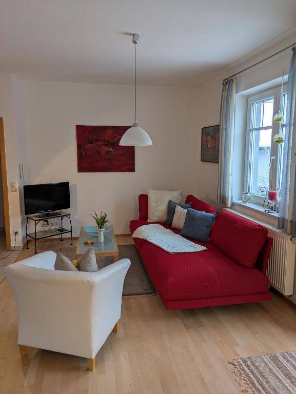 a living room with a red and white couch at Ferienwohnung zum Utzen in Berching