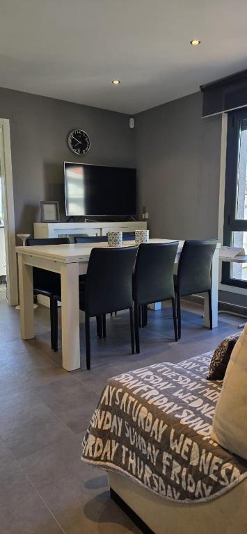 a living room with a table and chairs and a television at Casa Arena 2 in Nigrán