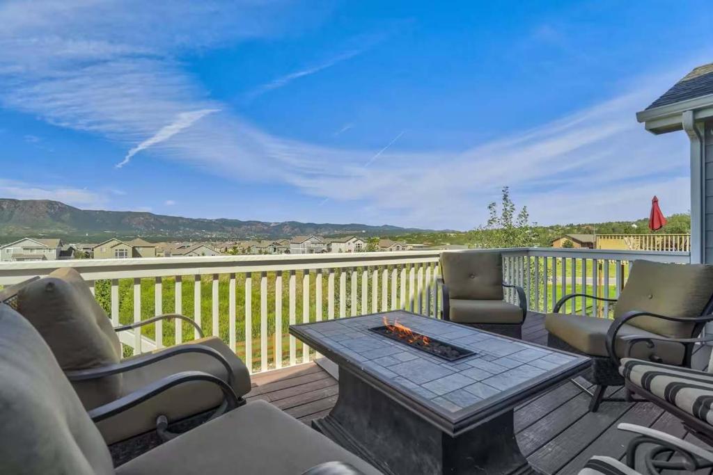 a patio with a table and chairs on a deck at Rangeview Pass Pet Friendly with Epic Peak Views in Monument