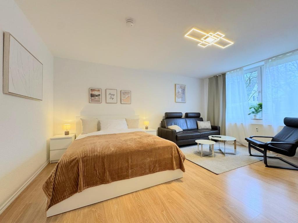 a large bedroom with a bed and a couch at Dein Apartment mit Queensize Bett im Erdgeschoss in Neukirchen-Vluyn