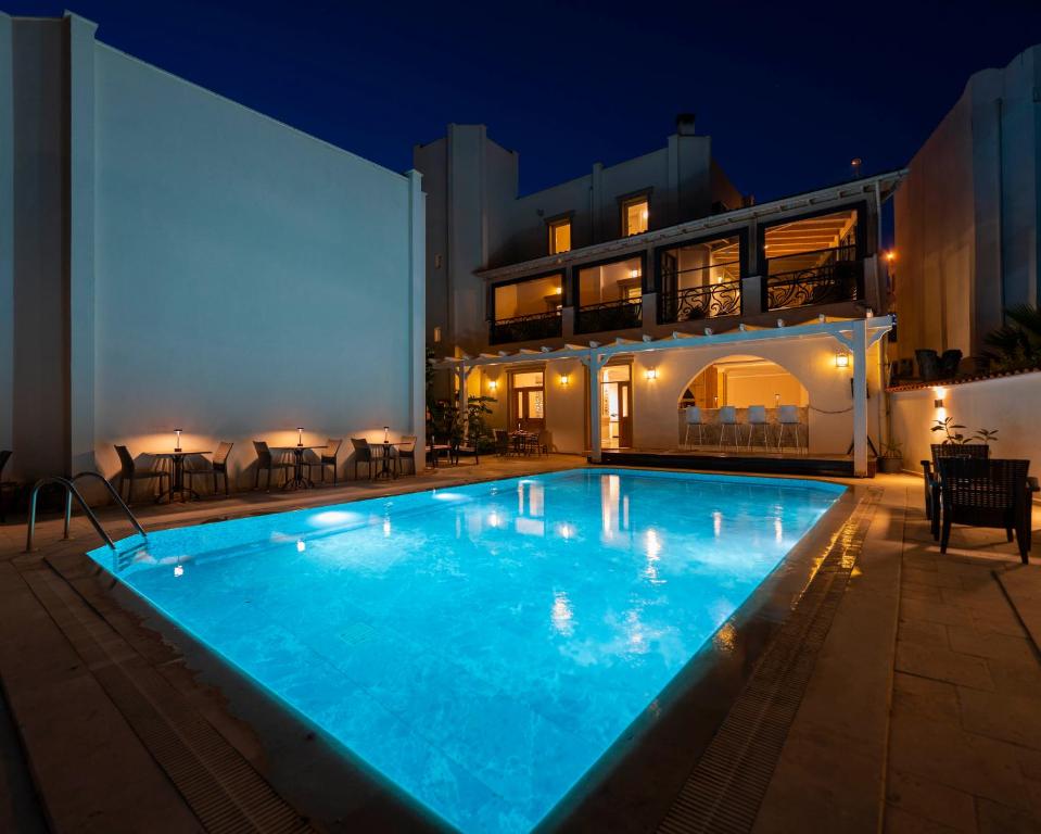 a swimming pool in front of a house at night at Porto Azul Hotel Bodrum in Bodrum City