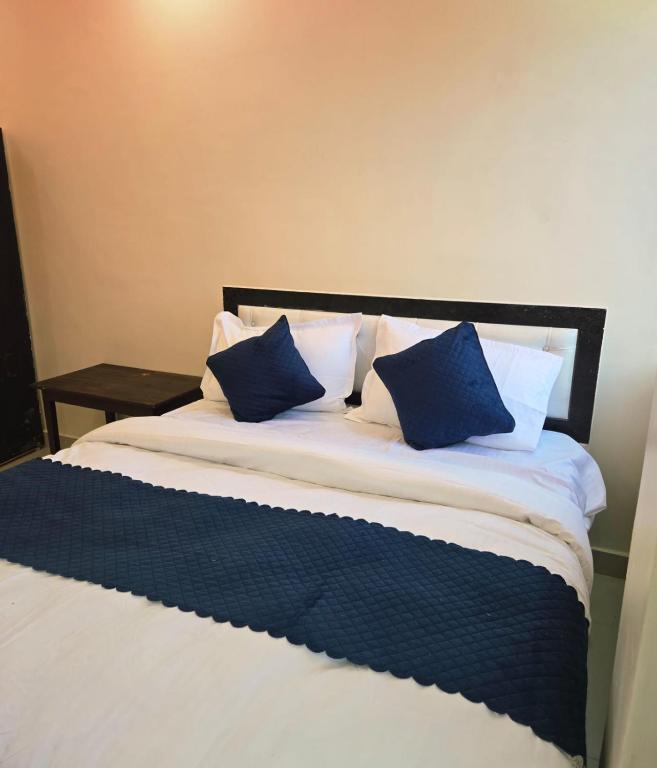 a bed with blue and white pillows on it at Laxmi raj awasiye hotel in Bettiah