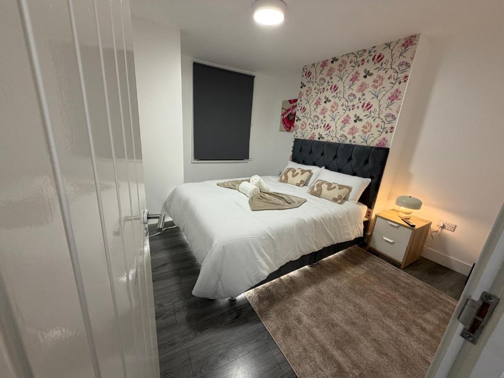 a small bedroom with a white bed and a wall at Bpsairbnbltd in London
