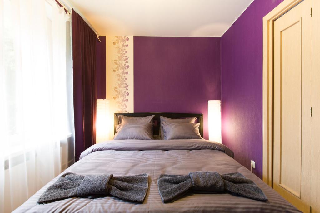 モスクワにあるLux Apartments Taganskayaの紫の壁のベッドルーム1室、ベッド1台(タオル付)