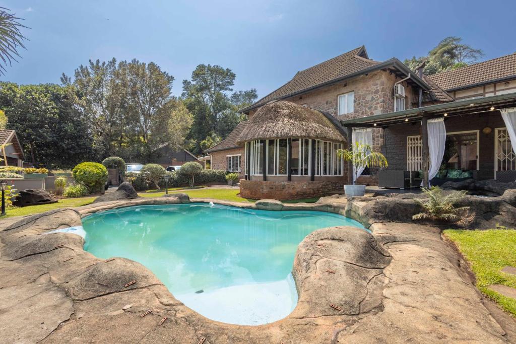 a house with a swimming pool in the yard at The Old Stone House in Kloof