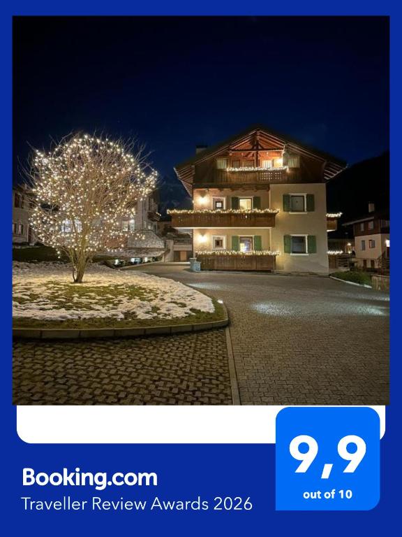 a building with a tree in front of it at night at Casa Le Rondini in Valdisotto