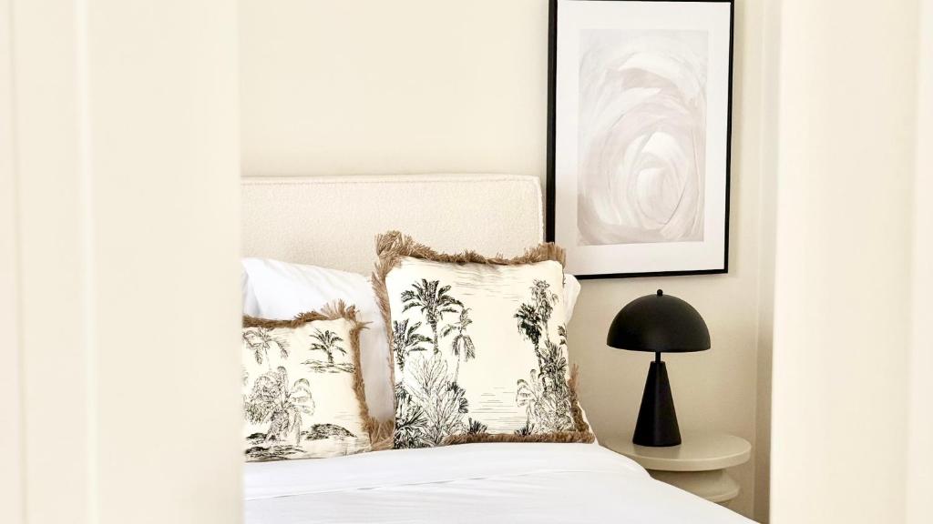 a bedroom with a bed with two pillows and a lamp at Bayab Charming Rooms - Corso Garibaldi in Benevento