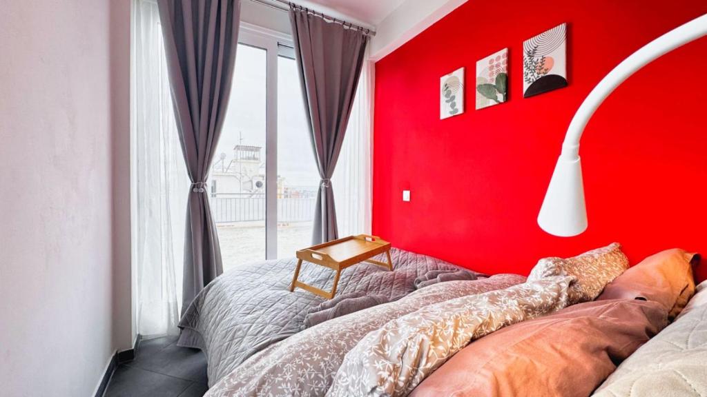 a red room with a bed with a red wall at House on the Top in Patra
