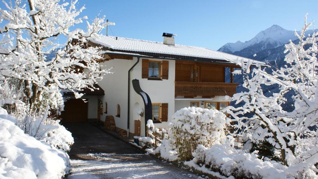 a house covered in snow in the mountains at Haus am Stein in Finkenberg
