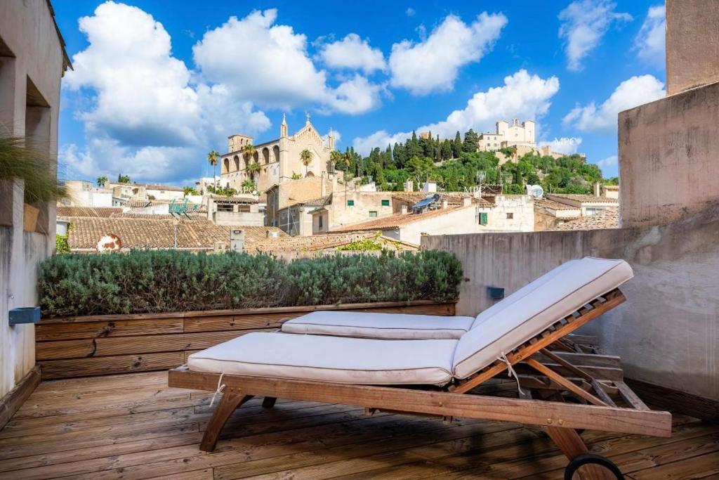 a bed on a balcony with a view of a city at Casa Puresa in Artá