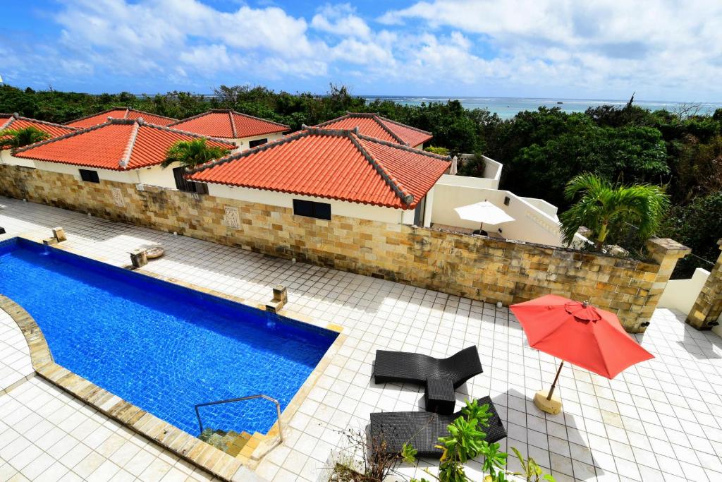 石垣島的住宿－戈蘭平約卡布什度假村，享有带游泳池的房屋的空中景致