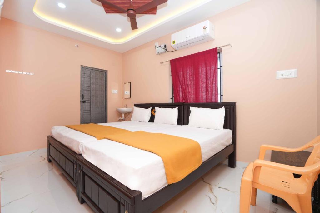 a bedroom with a large bed and a red window at Ramnath Residency in Rāmeswaram