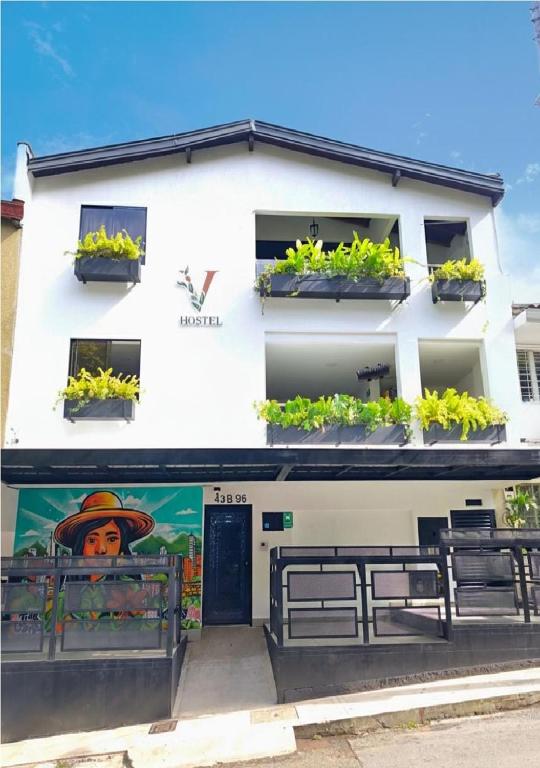 a white building with potted plants on the windows at Vida Hostel in Medellín