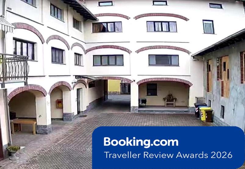 a large white building with a courtyard in front of it at Corte Cacciatori in Borgosesia