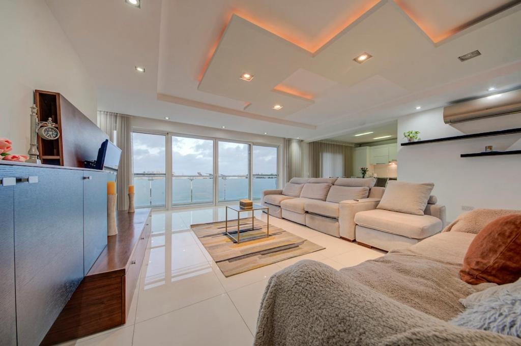 a living room with two couches and a television at Unique - Spacious 3BR Premium Flat in Is-Swieqi