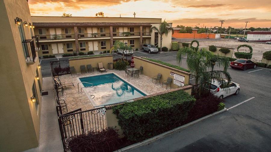 a view of a hotel with a pool and a parking lot at Barrokas Inn in Piedras Negras