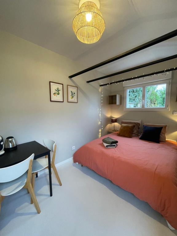 a bedroom with a red bed and a desk at Chez Sophie in Orléans