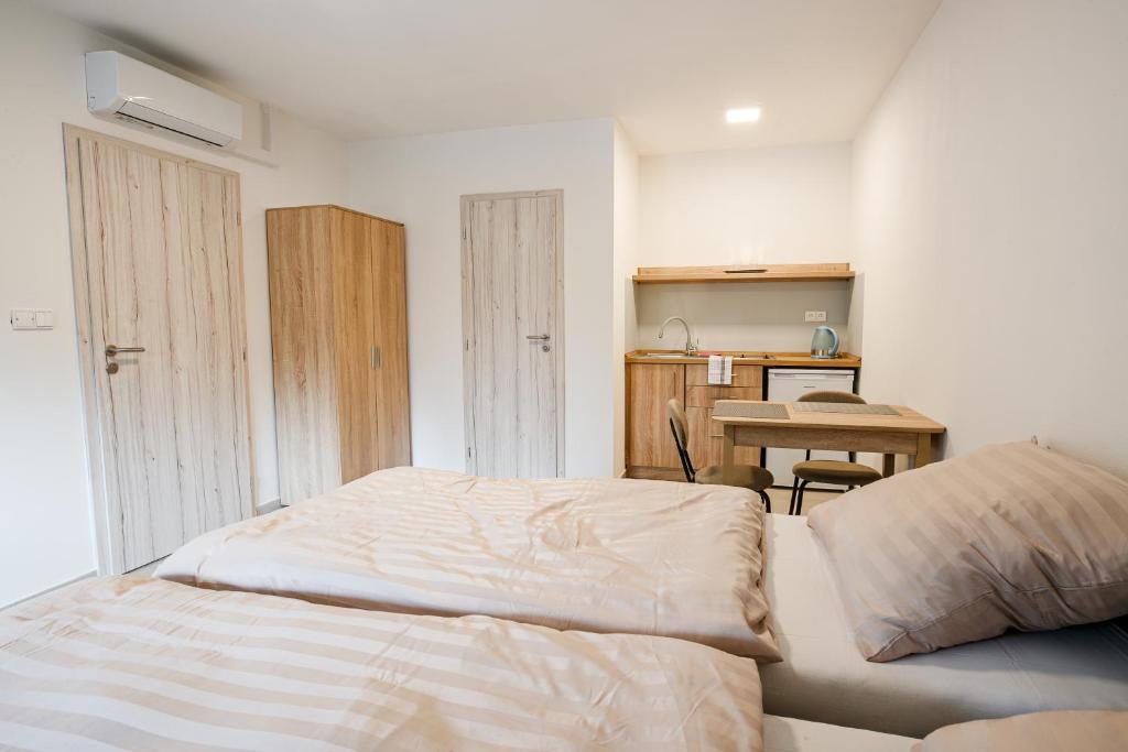 a bedroom with a bed and a kitchen with a table at Ubytování Smějsík in Blatnice